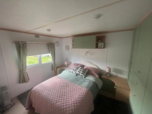 a small bedroom with a bed and a window at Belvedere Sleeps 4-6 in Skegness