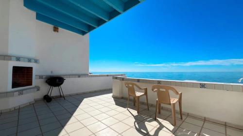 two chairs on a balcony with a view of the ocean at Charming and Cozy Beachfront Condo - Las Olas II 3 in Puerto Peñasco