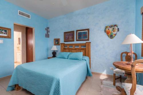 a blue bedroom with a bed and a table at Serene & Warm 3rd Level Condo - Corona del Mar 302 in Puerto Peñasco