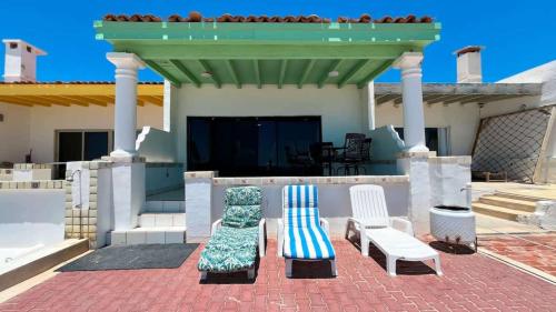 two chairs sitting on a patio in front of a house at Beautiful Beachfront Condo Las Olas II 11 in Puerto Peñasco