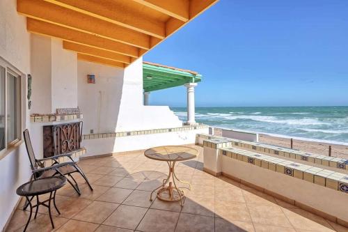a balcony with chairs and a table and the ocean at Cozy Beachfront Condo Las Olas II 10 in Puerto Peñasco