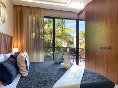 a bedroom with a large bed and a large window at Casa Alba in Puerto Morelos