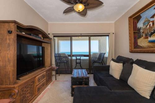 a living room with a couch and a flat screen tv at Unique Oceanfront with Epic Sunsets Pinacate 202 in Puerto Peñasco