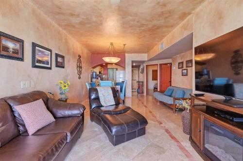 a living room with a leather couch and a tv at Charming Cozy Condo Great View Pinacate 404 in Puerto Peñasco