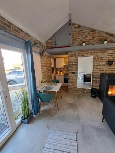 a living room with a table and a fireplace at Haillodge-gîte nature in Ohey