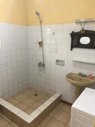 a bathroom with a shower and a sink at Chambre indépendante in Port-Gentil