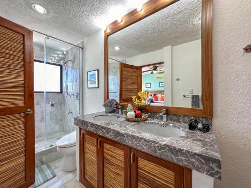 a bathroom with a sink and a toilet and a mirror at Casa Cuatro Estaciones in Puerto Morelos