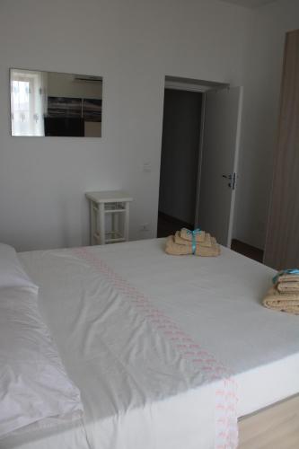 a white bed with two towels on top of it at Tropical House in Formia