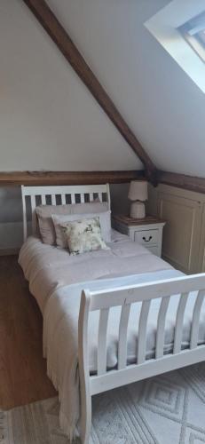 a bedroom with a white bed in a attic at Rockleigh House in Corsham