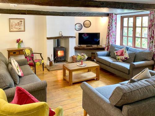 a living room with couches and a fire place at Brook House 1 - Uk1415 in Bassenthwaite