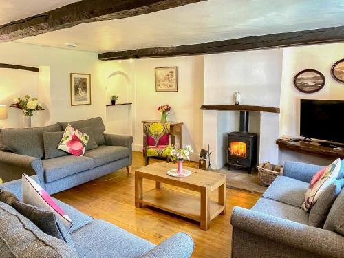 a living room with couches and a fire place at Brook House 1 - Uk1415 in Bassenthwaite