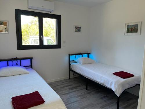 two beds in a room with a window at Gîte des Lauriers Blancs in Laurac-en-Vivarais