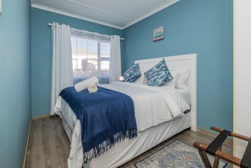 a blue bedroom with a bed and a window at Namclassics in Langstrand
