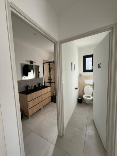 a bathroom with a toilet and a sink and a mirror at Gîte des Lauriers Blancs in Laurac-en-Vivarais
