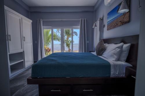 a bedroom with a bed with a view of the ocean at Villa Armoniosa Spacious Beachfront 2BR with Pool - Lower Level in Placencia