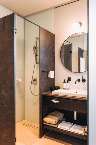 a bathroom with a sink and a shower at Hotel am See in Hard