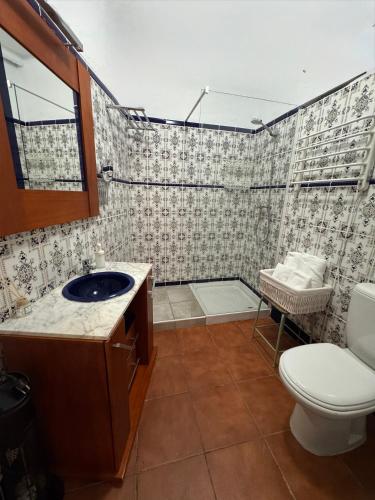 a bathroom with a sink and a toilet and a shower at Mil House in Cómpeta