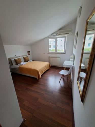 a bedroom with a bed and a table and a mirror at Apartments Iva in Kotor