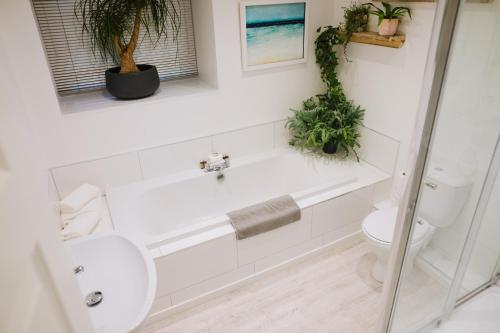 a white bathroom with a toilet and a sink at Snowdon Studio Apartment in Colwyn Bay