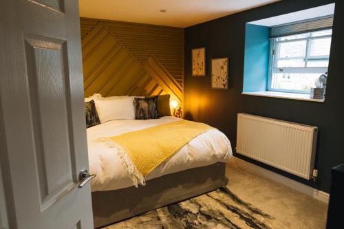 a bedroom with a bed with a wooden headboard and a window at Snowdon Studio Apartment in Colwyn Bay