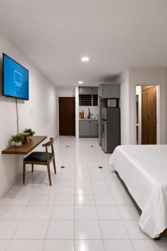 a bedroom with a bed and a table and a kitchen at The Oxford Suite in Kingston