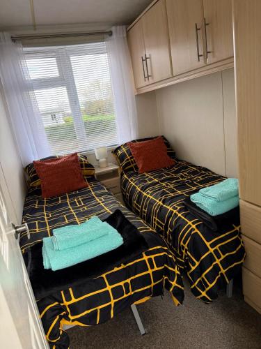 two beds in a small room with a window at Riverbank Lodge in Stratford-upon-Avon