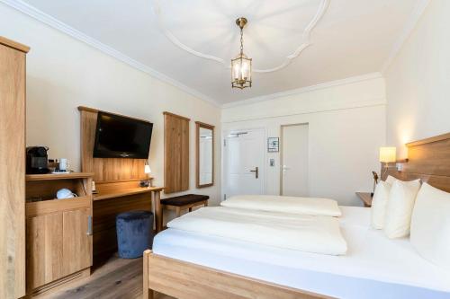 a bedroom with a bed and a flat screen tv at Alte Post in Lindau