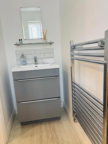 a bathroom with a sink and a mirror at Penuel 3-bedroom Retreat with workspace in Central Sutton-in-Ashfield in Sutton in Ashfield