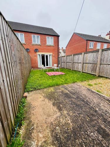 a yard with a fence and a house at Penuel near Sutton -In-Ashfield town centre in Sutton in Ashfield