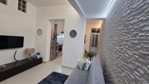 a living room with a couch and a brick wall at CASA CASCIOTTO in Palermo