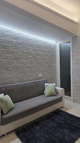 a couch in a living room with a brick wall at CASA CASCIOTTO in Palermo