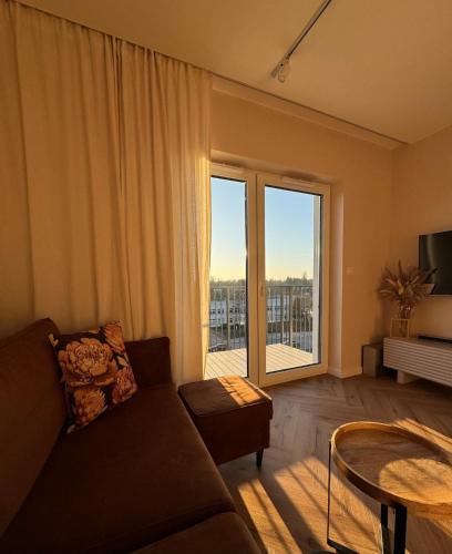 a living room with a couch and a table and a large window at BonjourApart in Łódź