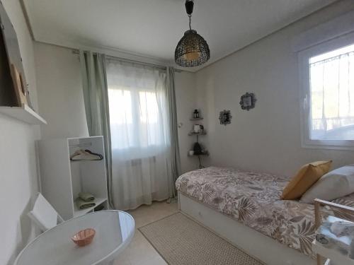 a bedroom with a bed and a table and a window at Casa María House in Zubiri