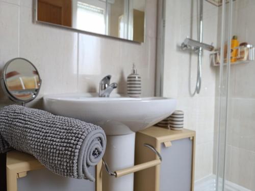 a bathroom with a white sink and a mirror at Casa María House in Zubiri