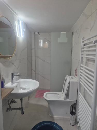 a white bathroom with a toilet and a sink at Casa Via Egnatia in Komotini