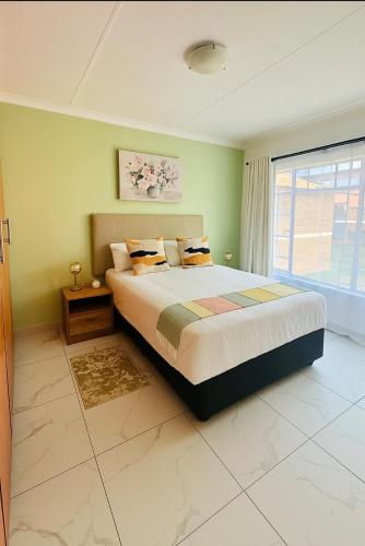 a bedroom with a large bed and a window at Brytelight Luxe 1 Bedroom in Rustenburg