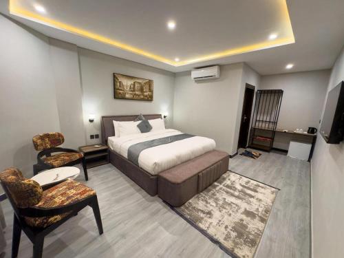 a hotel room with a bed and a chair at The Pioneer Hotel in Skardu