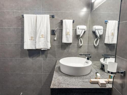 a bathroom with a sink and towels on a wall at The Pioneer Hotel in Skardu
