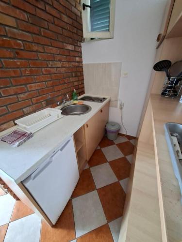 a kitchen with a sink and a brick wall at Apartments Iva in Kotor
