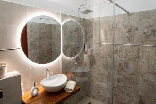 a bathroom with a sink and a glass shower at Vincellér Apartman in Villány