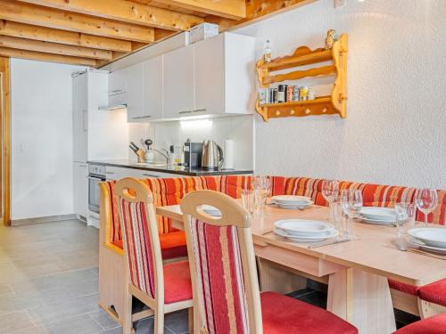 a kitchen and dining room with a wooden table and chairs at Chalet-Apartment mit Balkon & Gratis Parkplatz in Lenk