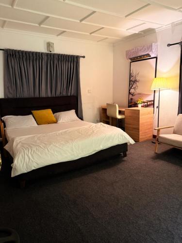 a bedroom with a bed and a chair and a mirror at Kath's Hub in Lagos