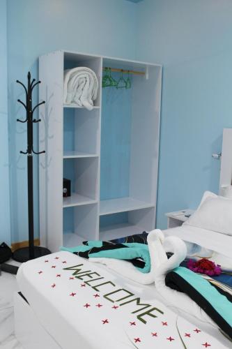 a bedroom with a white bed with a sign on it at Ocean Echo Villa in Mathiveri