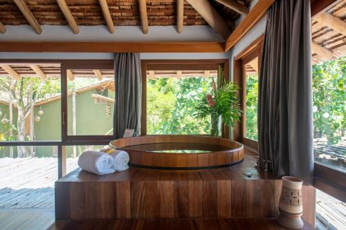 a bathroom with a round tub in a room with windows at Amaia Trancoso Hotel in Trancoso