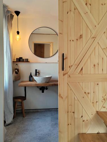 a bathroom with a wooden door and a sink at Chata Fraluq in Tatobity