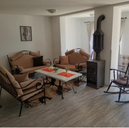 a living room with couches and a table and a stove at Bovan vikendica za izdavanje in Jezero