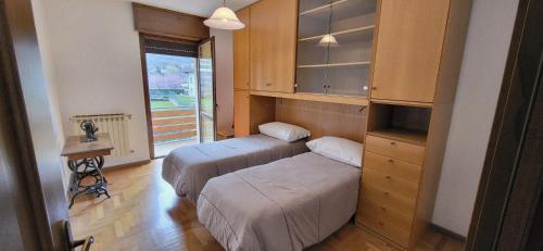 two beds in a small room with a window at Casa Leonardo in Tirano