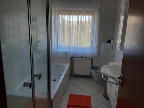ein Badezimmer mit Dusche, Badewanne und Waschbecken in der Unterkunft Ferienwohnung Freiling in Wilhelmshütte