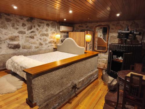 a bedroom with a bed and a stone wall at My Portugal for All - Lousada Villa in Lousada