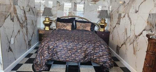 a bedroom with a bed with a blanket and two lamps at E & E Motel in Myrtle Beach